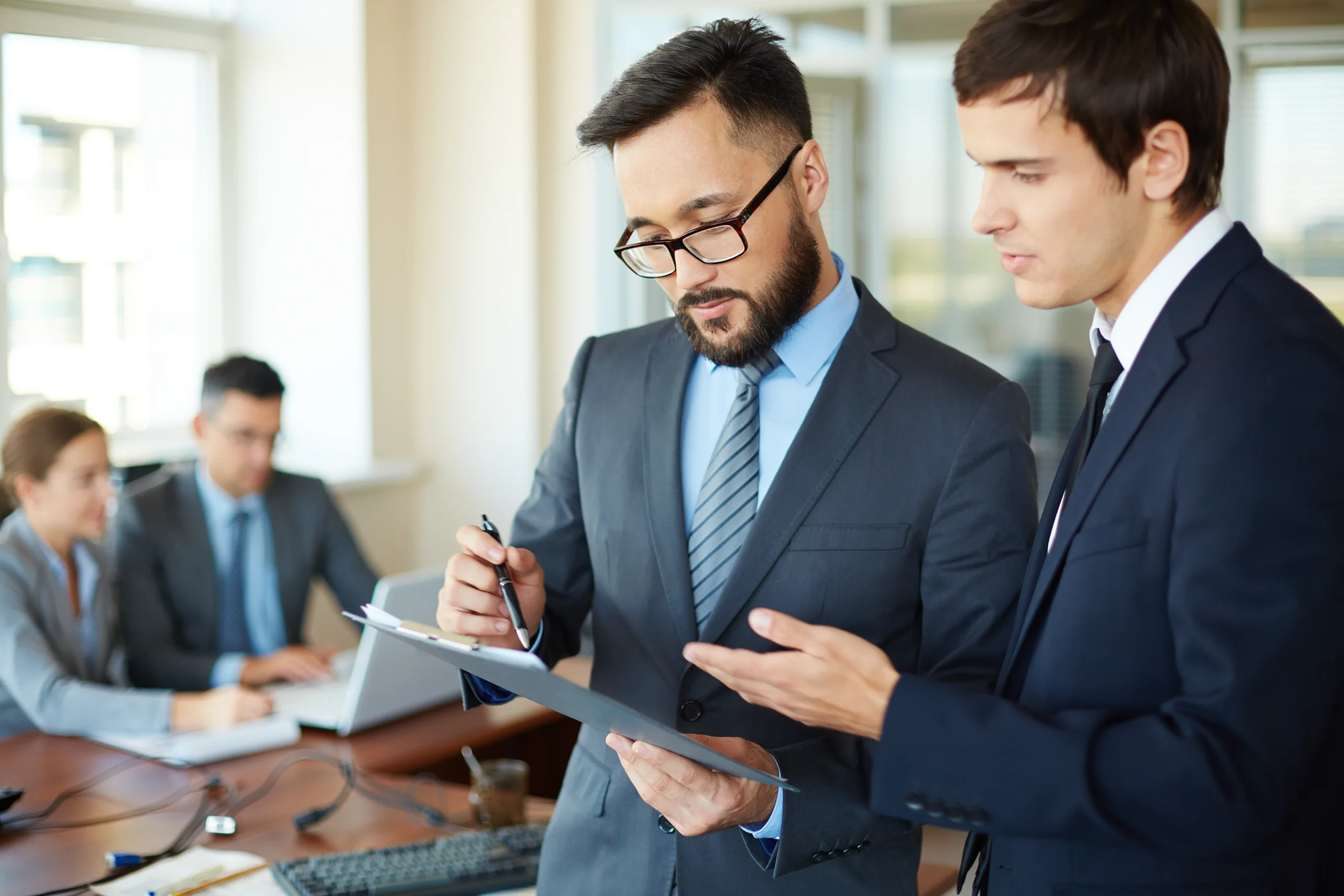 two-young-businessmen-with-report-scaled